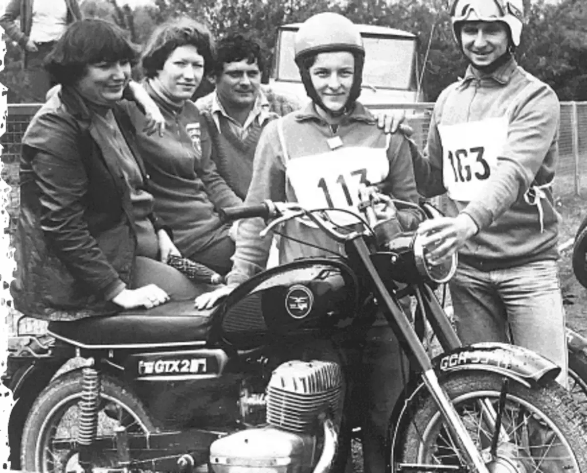 Archiwalne zdjęcie: zawodnicy z numerami startowymi i kibice przy motocyklu